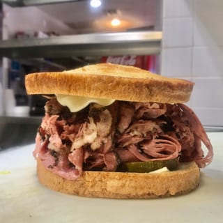 Sy Ginsberg Brand Corned Beef or Pastrami Sandwich on Rye, Onion Roll or Kaiser Roll with Fries or Slaw
